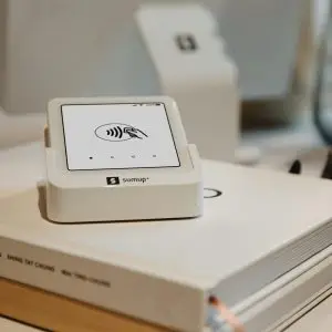 Close-up of the SumUp Solo card reader resting on a book in a warm, minimal retail setup. A modern and clean environment that highlights the elegance of digital payment tools for small businesses.